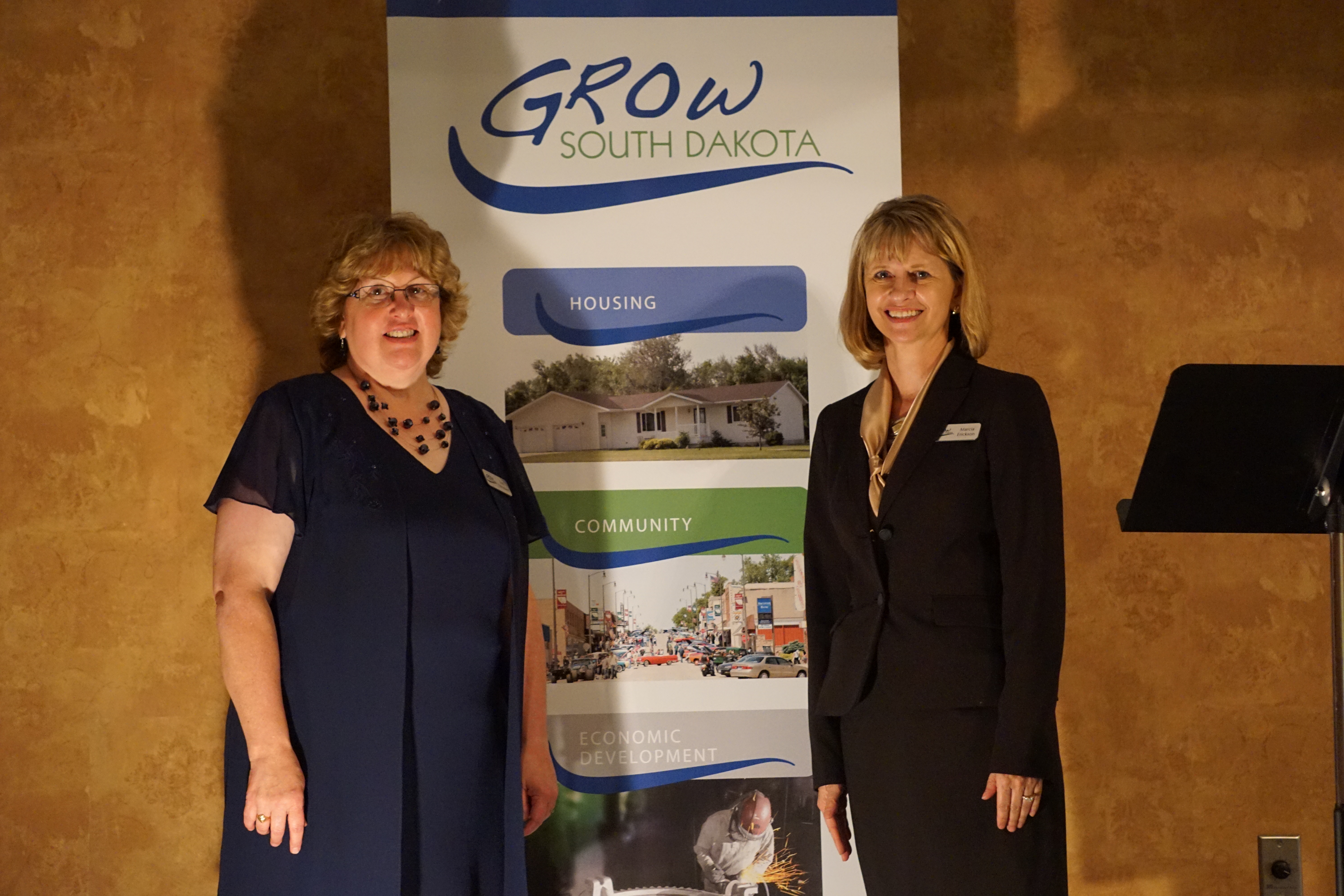 Lori and Marcia in front of a grow sign. Photo courtesy of Marcia Erickson.