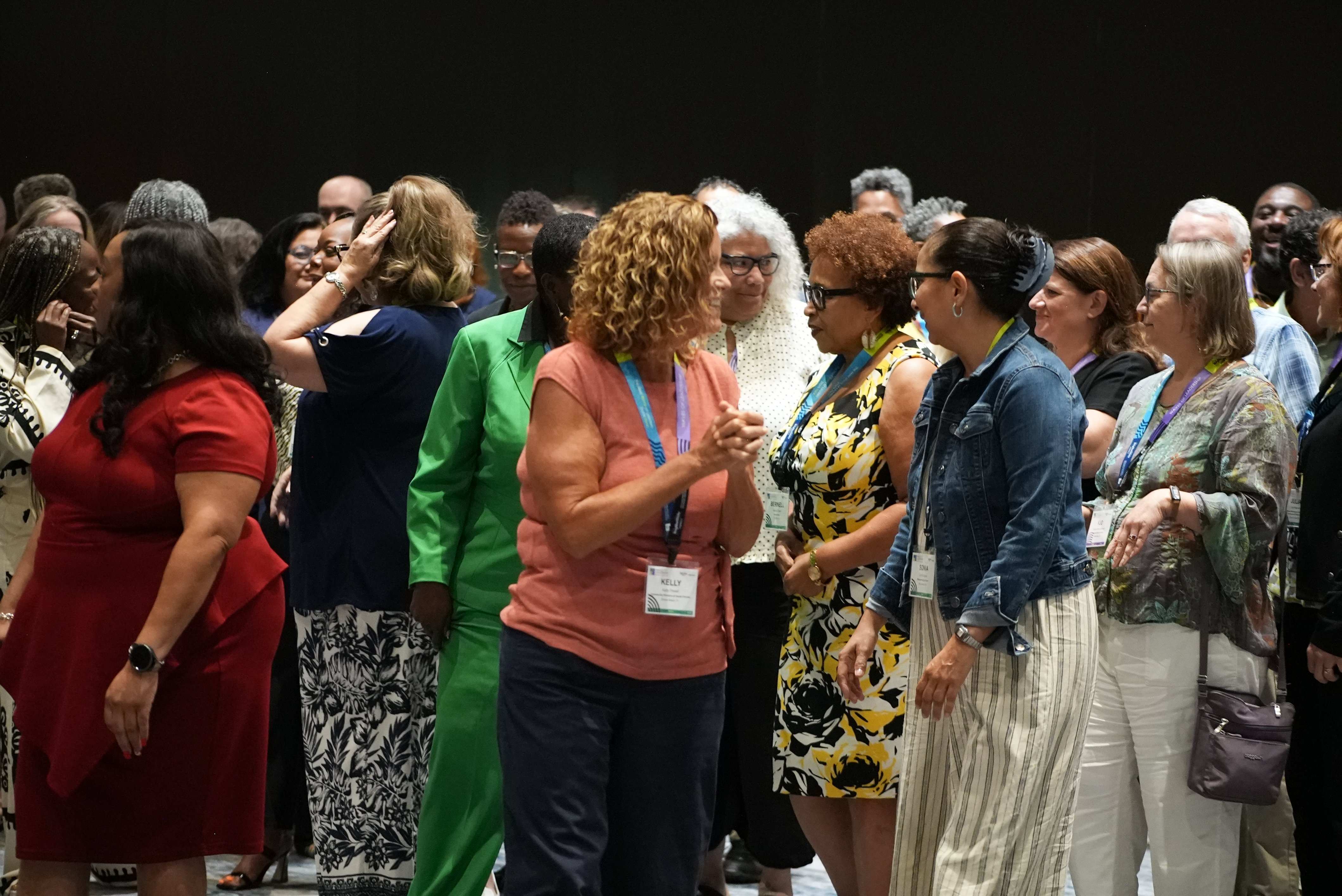 The participants visit with one another as they prepare for a group photo.