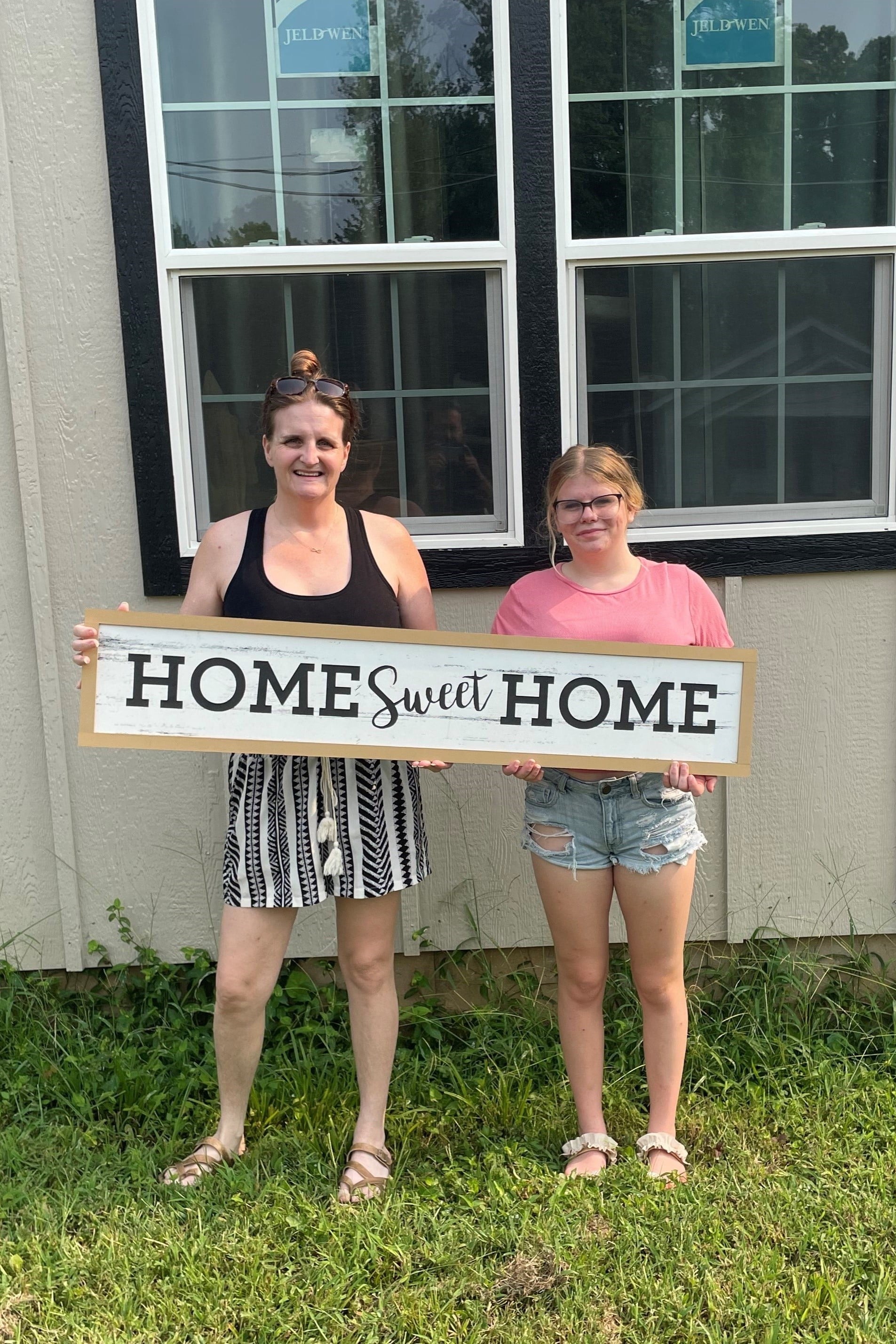 Jolene and her daughter in front of their new home.