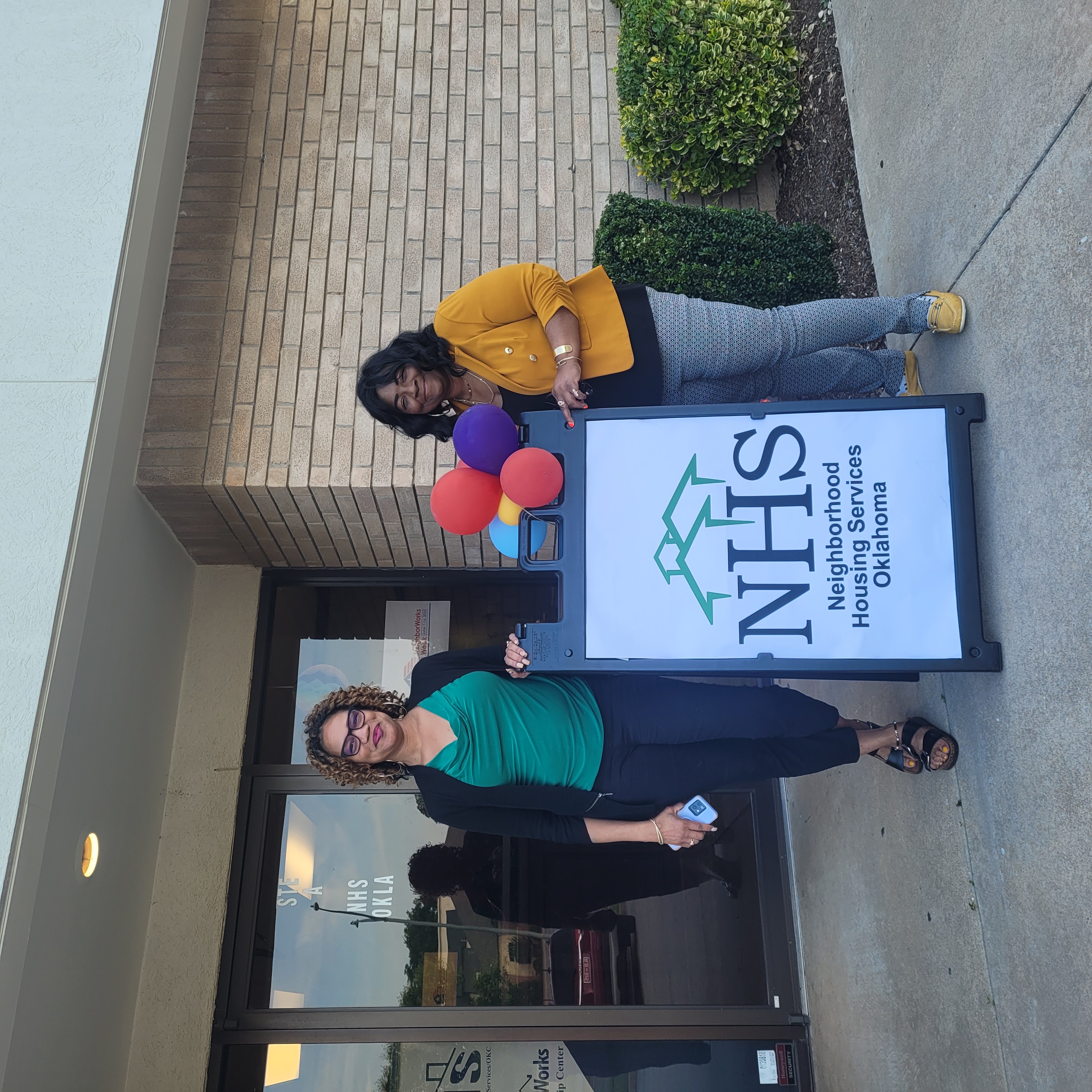 Staff at NHS of Oklahoma pose with a sign.