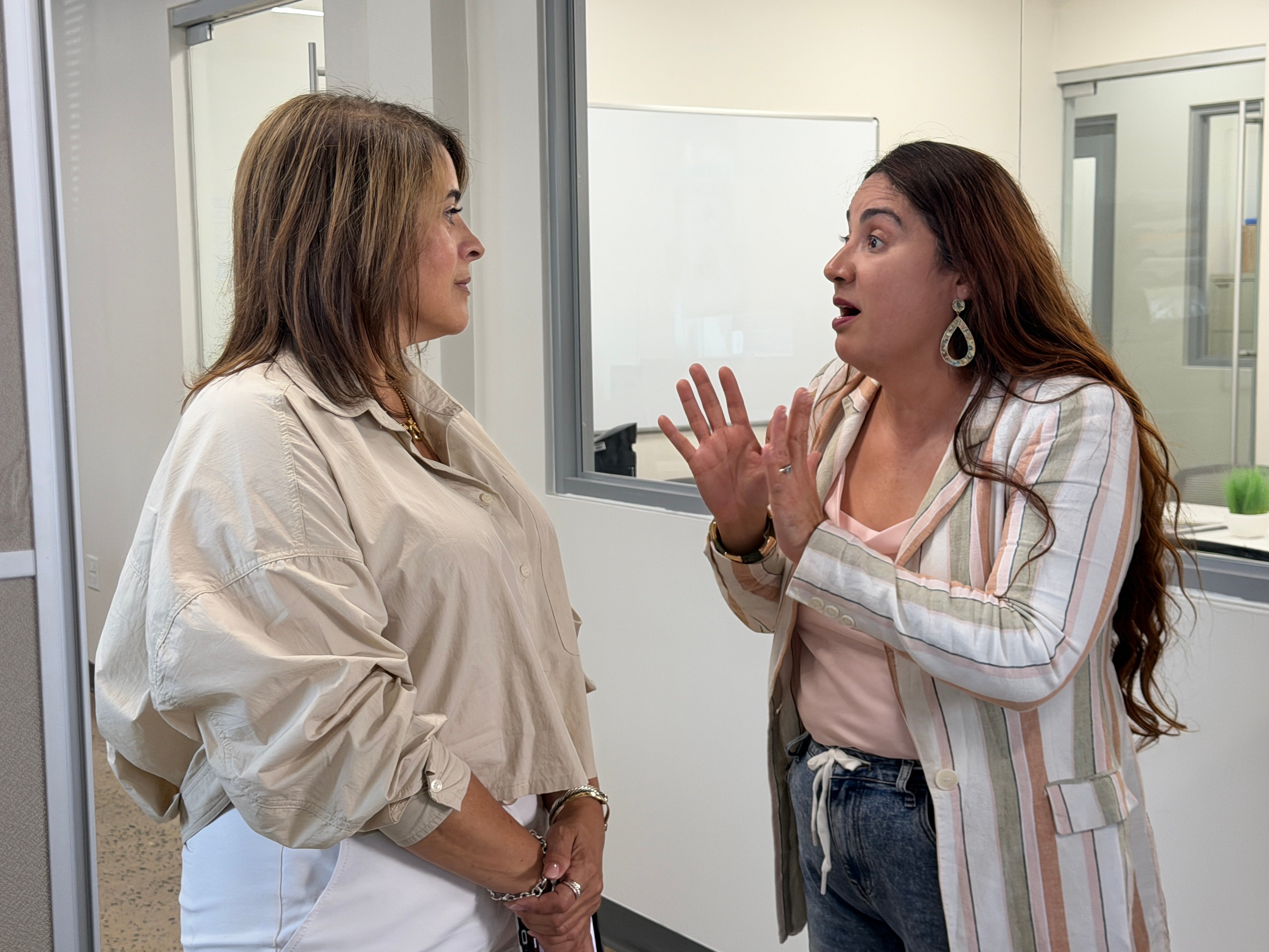 The conversation continues. Image shows two women in animated conversation.