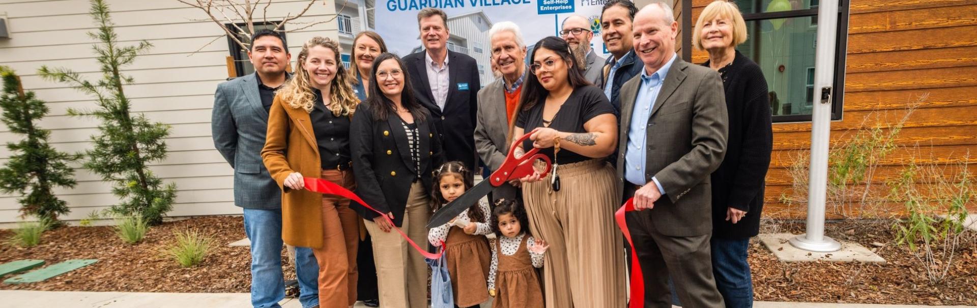 A group gathers to celebrate Guardian Village.