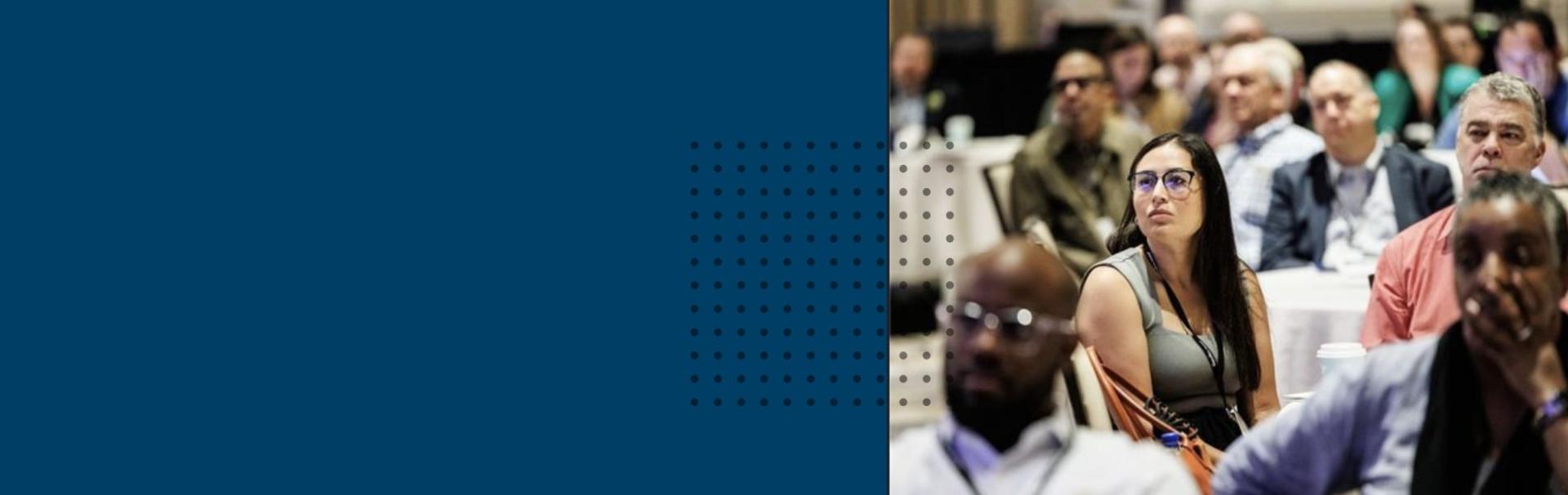 A photo of the executive symposium shows a crowd where the focal point is a woman in glasses.