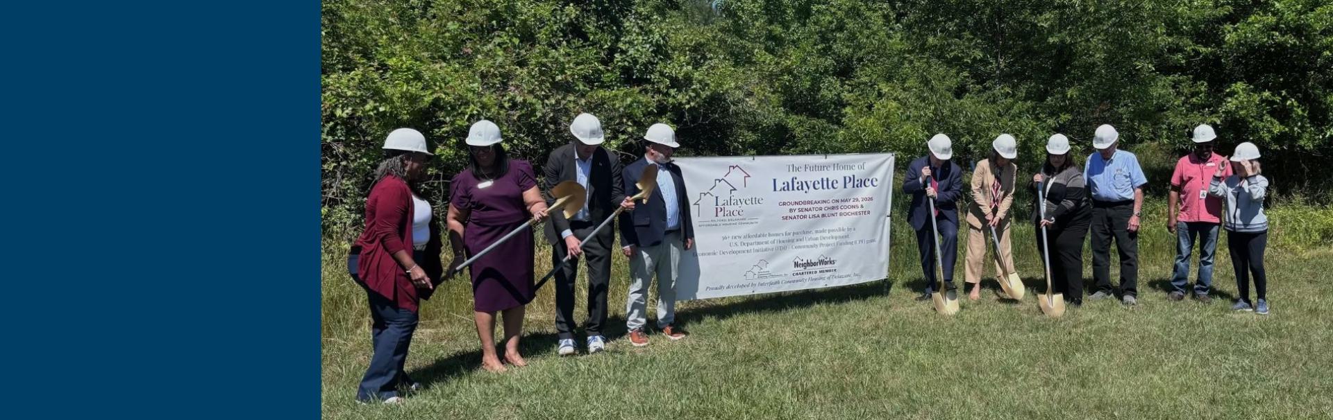 Senators, the Delaware governor, Milford's Mayor, NeighborWorks President & CEO Marietta Rodriguez join staff from Interfaith Community Housing of Delaware Inc., at the groundbreaking of Lafeyette Place. The photo shows the dignitaries lined up and carying shovels in front of a line of trees.