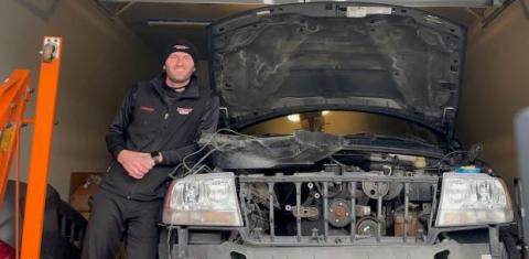 Dawson poses with his Jeep, which he's restoring in his new garage.