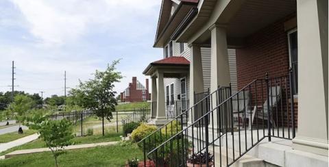A photo of several homes, side by side, with blue sky in the background.