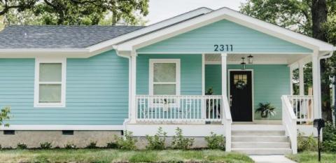 A cute blue house with a white porch.