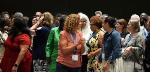 It's a reunion! The group talks and visits during the 25-year-reunion of the NeighborWorks Achieving Excellence Program.